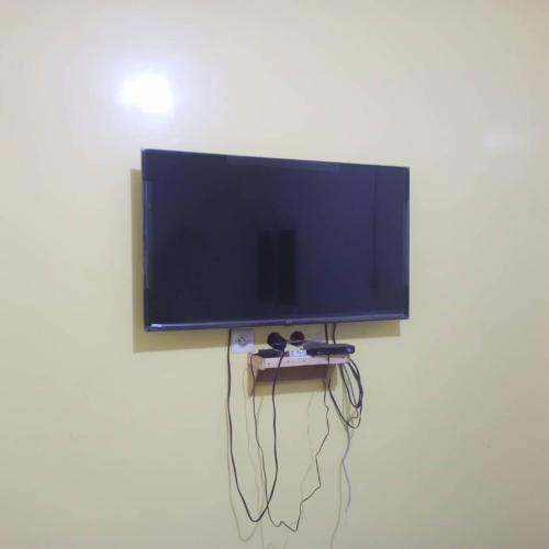 Un televisor de pantalla plana colgado en una pared en Appartement chez Alioune, en Tilel