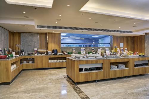 a restaurant with wooden counters with food on display at Cygnett Inn Airport in Mohāna