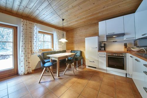 una cucina con tavolo e sedie in una stanza di Appartement Kolling a Saalbach Hinterglemm