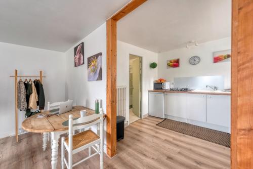 une cuisine et une salle à manger avec une table et un comptoir dans l'établissement Le Cosy, à Lannion