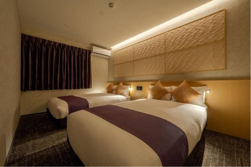 a hotel room with two beds and a large window at RESI STAY Kuon in Kyoto