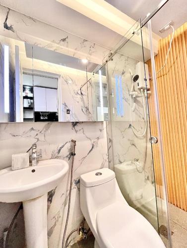een badkamer met een toilet, een wastafel en een douche bij City View Suite in Manilla