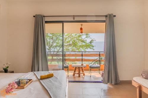 a bedroom with a bed and a large window at Avanti Kalagram Hill Top Resort, Mulshi in Kolvan