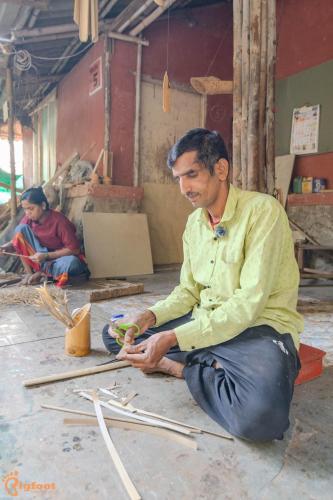 a man sitting on the floor working on a piece of wood at Avanti Kalagram Hill Top Resort, Mulshi in Kolvan