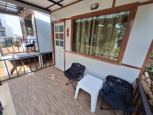 a balcony with two chairs and a table and a window at Slumberland at Pai in Pai