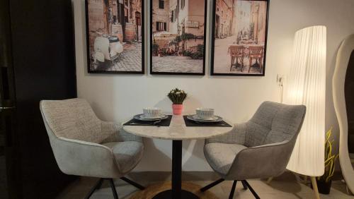 a table and chairs in a room with pictures on the wall at Deluxe Studio - Stylish & Cosy in Luma22 in Dubai