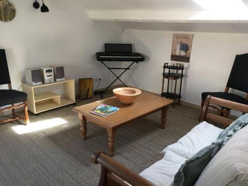 un salon avec une table basse et un clavier dans l'établissement Mirabeau Bel appartement en sud Luberon, à Mirebeau