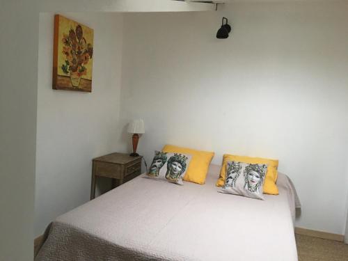 une chambre avec un lit avec des oreillers jaunes dans l'établissement Mirabeau Bel appartement en sud Luberon, à Mirebeau