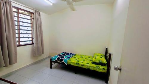 a small bed in a room with a window at Teratak Anies Semi-D Bypass Homestay Kuantan in Kuantan