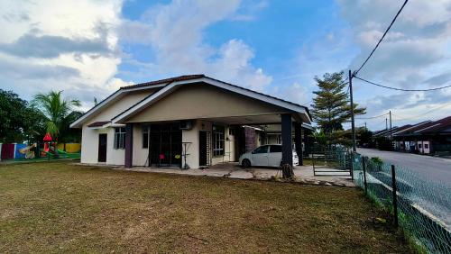 a small house with a car parked in front of it at Teratak Anies Semi-D Bypass Homestay Kuantan in Kuantan