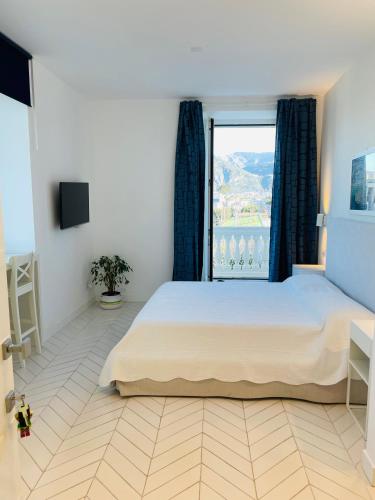 a bedroom with a large bed and a large window at Casa Torre a Sorrento con parcheggio gratuito in Sorrento