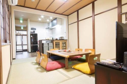 a kitchen with a table and chairs in a room at Goemon House 五右衛門ハウス in Osaka