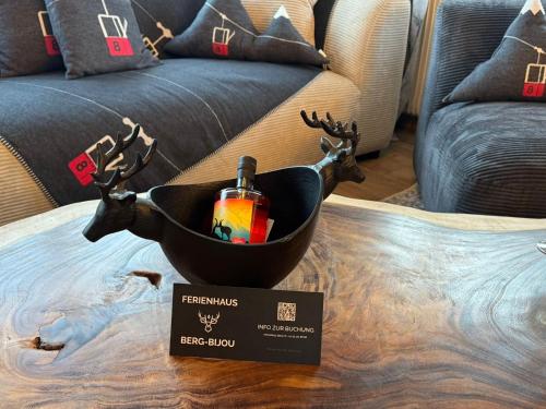 a table with a basket with a bottle of wine and deer antlers at Berg-Bijou Scuol in Scuol