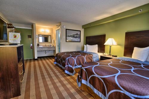 a hotel room with two beds and a kitchen at Super 8 by Wyndham Bangor in Bangor