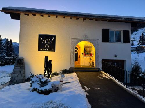 a white house with snow in front of it at Berg-Bijou Scuol in Scuol