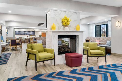 a living room with chairs and a fireplace at Hampton Inn Detroit/Auburn Hills-North in Auburn Hills