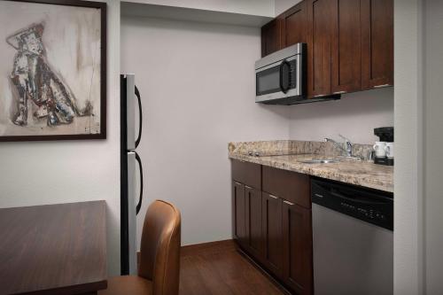 a small kitchen with a refrigerator and a sink at Homewood Suites by Hilton Seattle/Lynnwood in Lynnwood