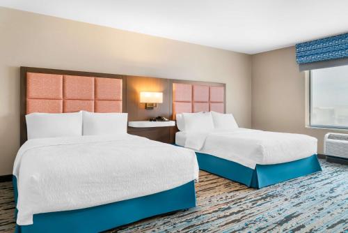 a hotel room with two beds and a window at Hampton Inn Detroit/Auburn Hills-North in Auburn Hills