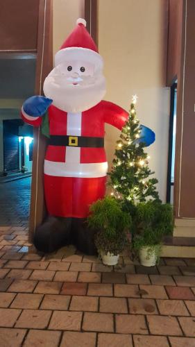 a santa claus is standing next to a christmas tree at NEW MOUNT RESIDENCY in Sultan Bathery