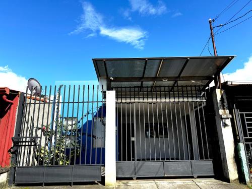 a black gate with a black roof at Casa Matiza, 7 min SJO airport, free parking, AC in Santiago Este