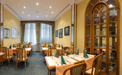 a dining room with tables and chairs and a window at Galerie Hotel Leipziger Hof in Leipzig