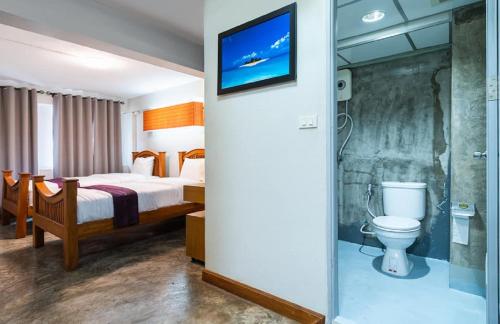 a hotel room with a bed and a toilet at XX GO INN Khaosan ข้าวสาร กรุงเทพมหานคร in Bangkok