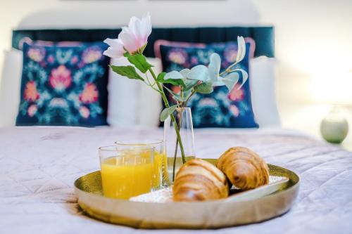 a tray of croissants and orange juice and a plate of pastries at Victoria Park Studio 11 - Free Parking, WiFi, Near Town Centre, Free DisneyPlus, Prime & Netflix in Leamington Spa