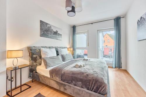 a bedroom with a bed and a large window at Traumferienwohnung Domblick 2 I Altstadtnähe I Zentrale Lage I Balkon mit Domblick I Stilvoll in Limburg an der Lahn
