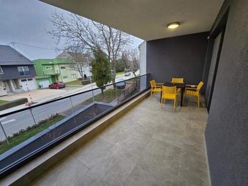 a balcony with a table and chairs and a view of a street at Apartman FIŠBAH II 2 self CHECK-IN, FREE PRIVATE PARKING in Osijek