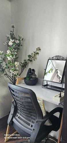a desk with a chair and a mirror and flowers at Relaxing Chic Hotel Like with Manila Bay view in Manila
