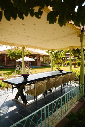 a table and chairs under an umbrella on a patio at Surpura Bagh - A Luxury Boutique Resort in Jodhpur