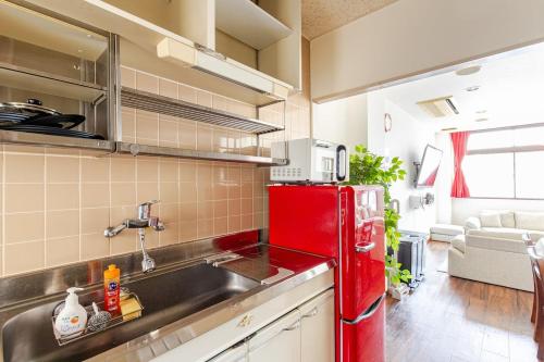 a kitchen with a red refrigerator and a sink at en stay001 in Osaka
