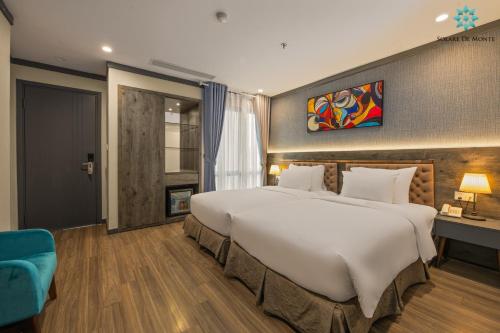 a large bedroom with a large bed and a blue chair at Solare De Monte Hotel & Spa in Hanoi