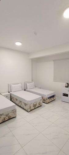 two beds in a room with white walls at عمارة دانة بنت أحمد Dana Bint Ahmed in Al Madinah