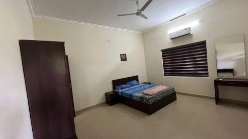 a bedroom with a bed and a mirror in it at Aura Villa in Kozhikode