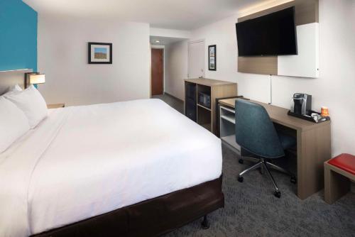 a hotel room with a bed and a desk with a computer at Comfort Inn & Suites Dahlonega University Area in Dahlonega