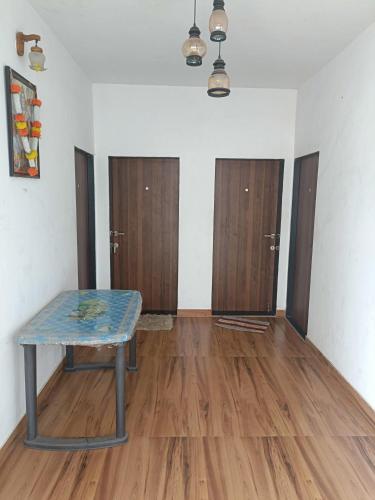 a room with a table and some wooden doors at Happy Holiday Home in Alibaug