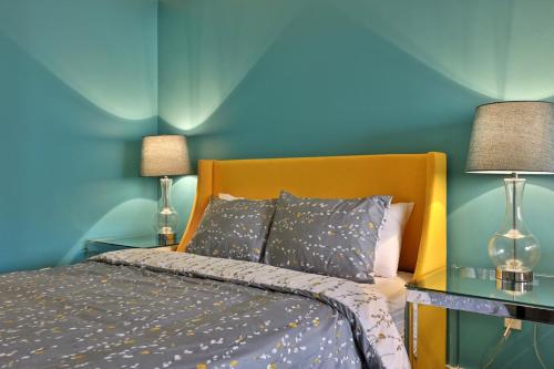 a bedroom with a bed with blue walls and two lamps at Tranquil Peaks Studio at KCIS - Perfect for a Getaway in the Heart of Vermont Ski Resort in Killington