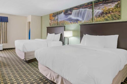 a hotel room with two beds and a painting on the wall at Clarion Pointe in Jasper