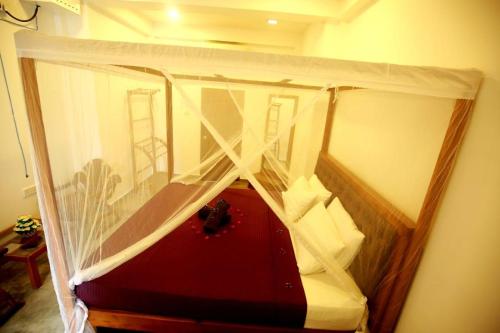 a corner of a room with a bed with curtains at Surf Heavens in Dickwella