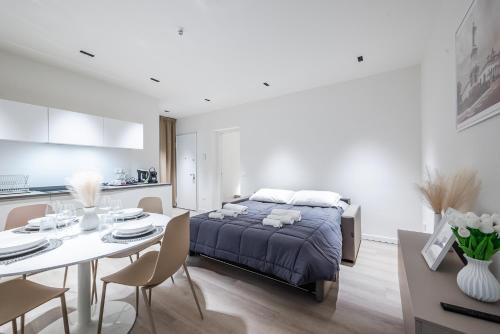 une chambre avec un lit et une table et une cuisine dans l'établissement Arnaldo Apt Luxury e Design in Duomo, à Brescia