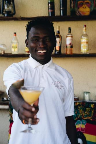 a man is holding a drink in his hand at Stasumo House Arusha in Arusha