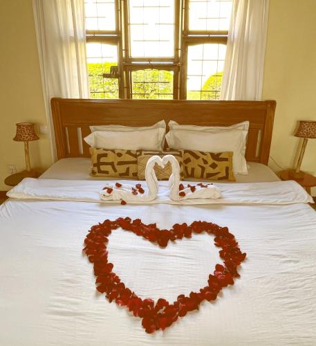 a heart on a bed with a heart made out of roses at Stasumo House Arusha in Arusha