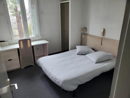 a bedroom with a large white bed with two pillows at Grand T4 Terrasse proche sanctuaire in Lourdes