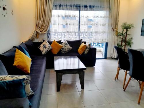 a living room with a couch and a table at Appartement complexe Costa Mar avec piscine privée très sécurisé 3min de la plage Luxe et détente in Martil