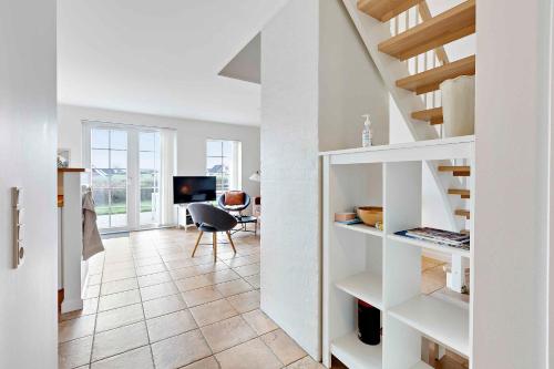 a living room with white shelves and a staircase at Charming Terraced House By The Beach And Forest in Bro