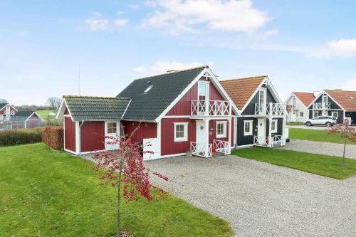 a house with a red and white house at Charming Terraced House By The Beach And Forest in Bro
