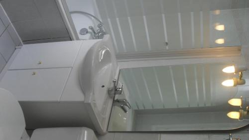 a white bathroom with a mirror and a toilet at Grand T4 Terrasse proche sanctuaire in Lourdes