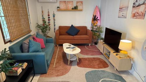a living room with two couches and a television at Bamboo Beach House @ Phang Nga in Thai Muang