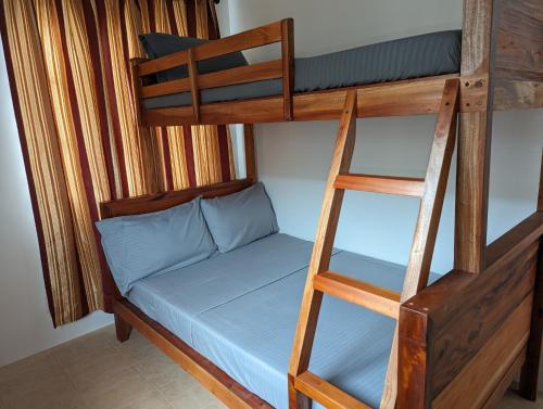 ein Etagenbett mit Leiter und ein Etagenbett mit einem blauen Bett in der Unterkunft Balay Hermosa in Dauis